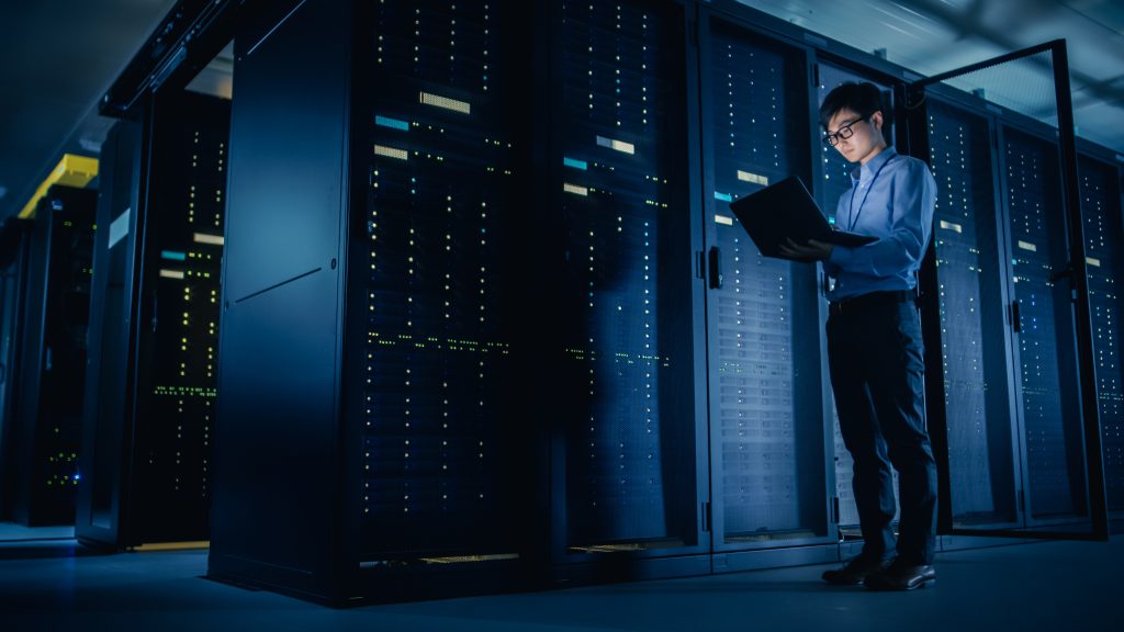 Technician working beside virtualization infrastructure in a data center